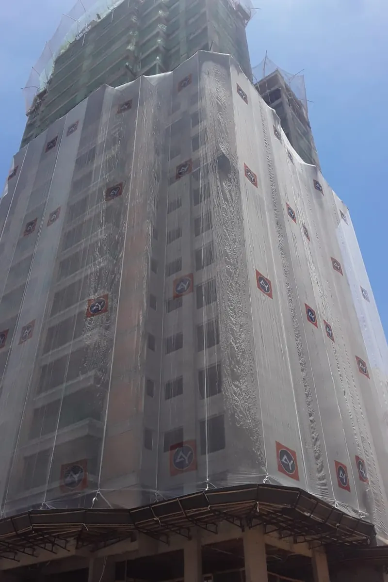 Fachada de edifício em obra envolvida por tela de proteção Volmax