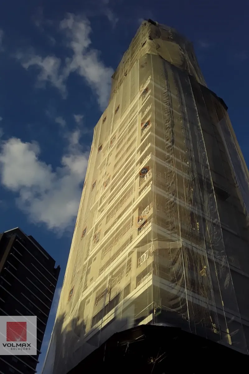 Torre em acabamento com tela fachadeira cobrindo a fachada inteira