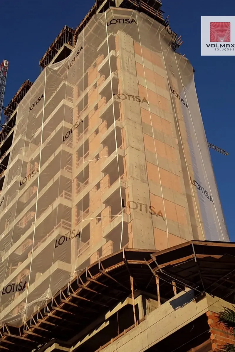 Edifício em estrutura com tela de proteção nas duas fachadas