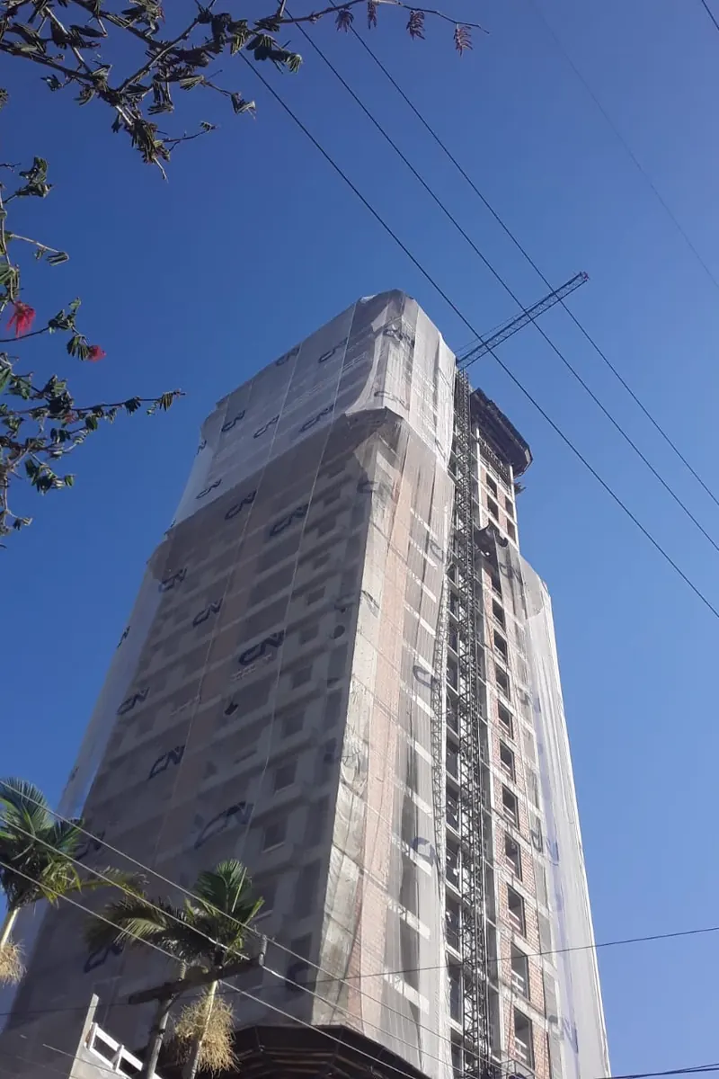 Prédio residencial em obra com tela fachadeira instalada